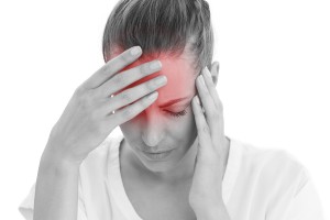 Woman having a headache with her head in her hands on white back